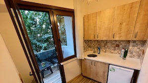 Una cocina compacta con armarios de madera, una encimera blanca y lavavajillas integrado.