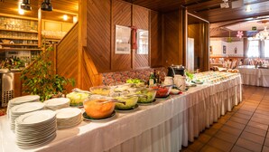 A buffet setup with various food items and a stack of plates. - Hotel Krimmlerfälle (Krimml)