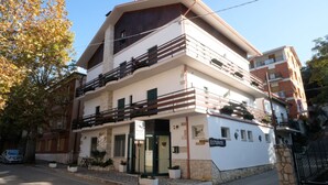 A two-story hotel with a stone facade, a balcony on the upper floor, and a sign indicating a restaurant on the ground floor. - Hotel Pescofalcone (Caramanico Terme)