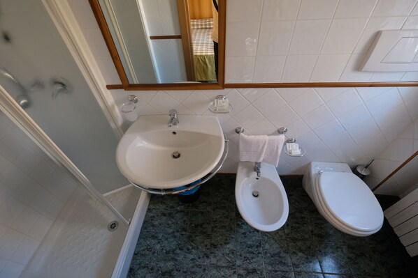 Un baño con lavamanos, bidé e inodoro.