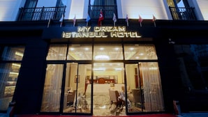 Exterior del My Dream Istanbul Hotel, con alfombra roja en la entrada y banderas.