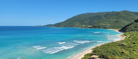 Una playa cerca, sillas reclinables de playa, toallas de playa