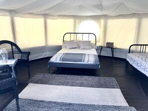 Cozy retreat with two beds, a small table, and a chair, perfect for a comfortable stay.