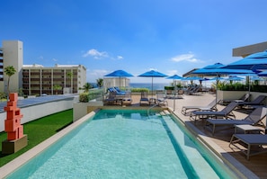 A pool area with clear blue water, lounge chairs, and umbrellas. - Hilton Cancun Mar Caribe All-Inclusive Resort (Cancun)