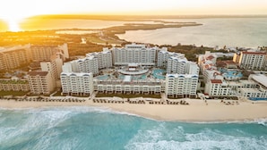 A resort with multiple buildings, a beach, and a large body of water. - Hilton Cancun Mar Caribe All-Inclusive Resort (Cancun)