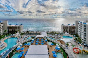 A resort with multiple swimming pools, sun loungers, umbrellas, and a view of the ocean. - Hilton Cancun Mar Caribe All-Inclusive Resort (Cancun)