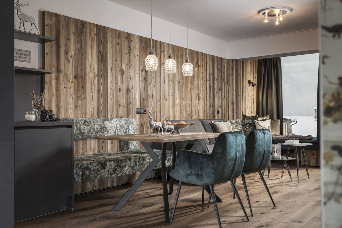Un espace repas moderne avec un mur en bois, une table en bois et trois chaises.