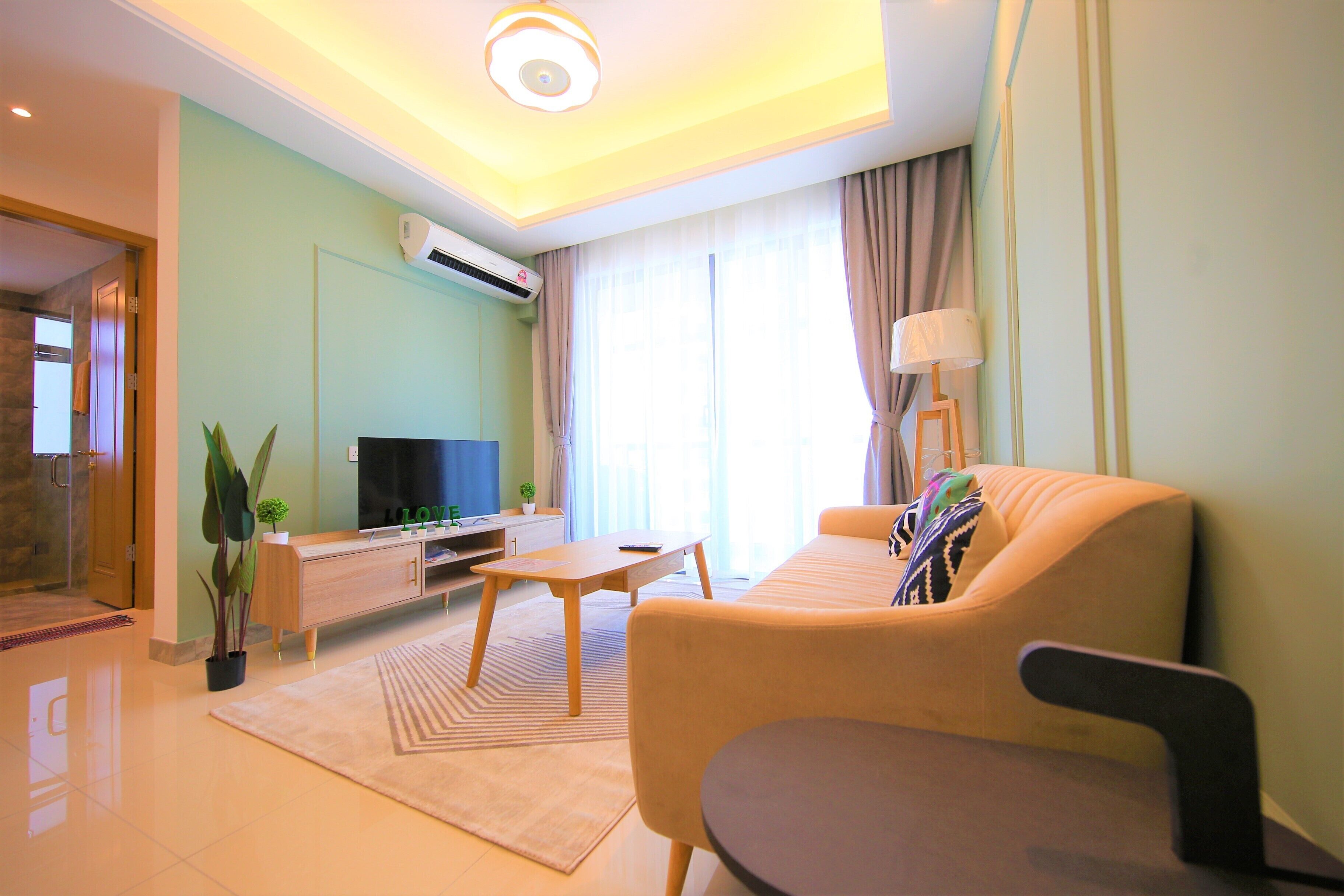 A modern living room with a sofa, a coffee table, a TV, and a potted plant.