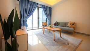 A modern living room with a sofa, coffee table, and a large window with curtains. - R&F Princess Cove at R&F Mall (Johor Bahru)