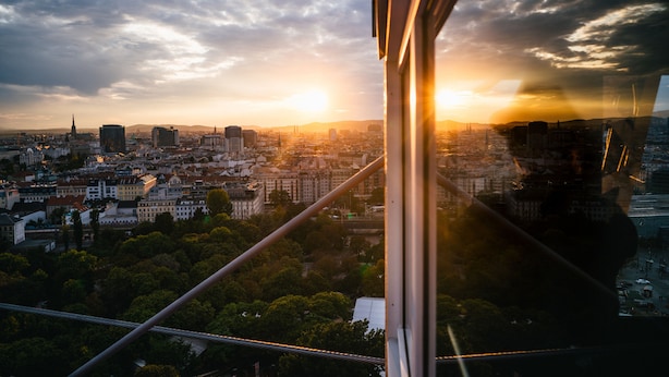 Un paisaje urbano con un puente destacado y un atardecer.