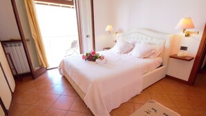 A bedroom with a large bed, two bedside lamps, a nightstand, and a view of the outdoors. - Pognana Luxury Apartment n.1 - 7 people (Pognana Lario)