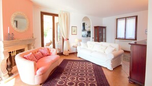 A living room with a fireplace, two sofas, a patterned rug, and a mirror on the wall. - Pognana Luxury Apartment n.1 - 7 people (Pognana Lario)
