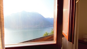 Ein Fenster mit Blick auf einen See und Berge.