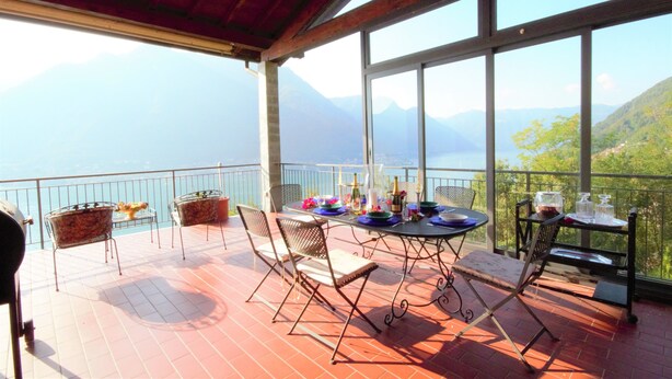 Eine Terrasse mit Esstisch, Stühlen und Blick auf die Berge.