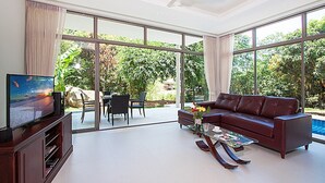A spacious living room with a large TV, a leather sofa, and a coffee table. - 2 Bedroom Pool Villa in Quiet Location SDV005 By Samui Dream Villas (Tambon Mae Nam)