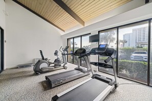 Uma academia com esteiras, elíptico e bicicleta ergométrica.
