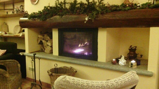Un salon chaleureux avec une cheminée, des meubles en osier et des décorations de fêtes.