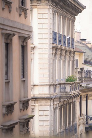 A building with classical architecture, featuring ornate columns and balconies. - Speronari Suites (Milan)
