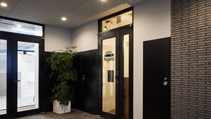 Ein Hotel Eingang mit einem Blumentopf, einer Glastür und einem Schild mit der Aufschrift 'HOTEL MIZUKA'.