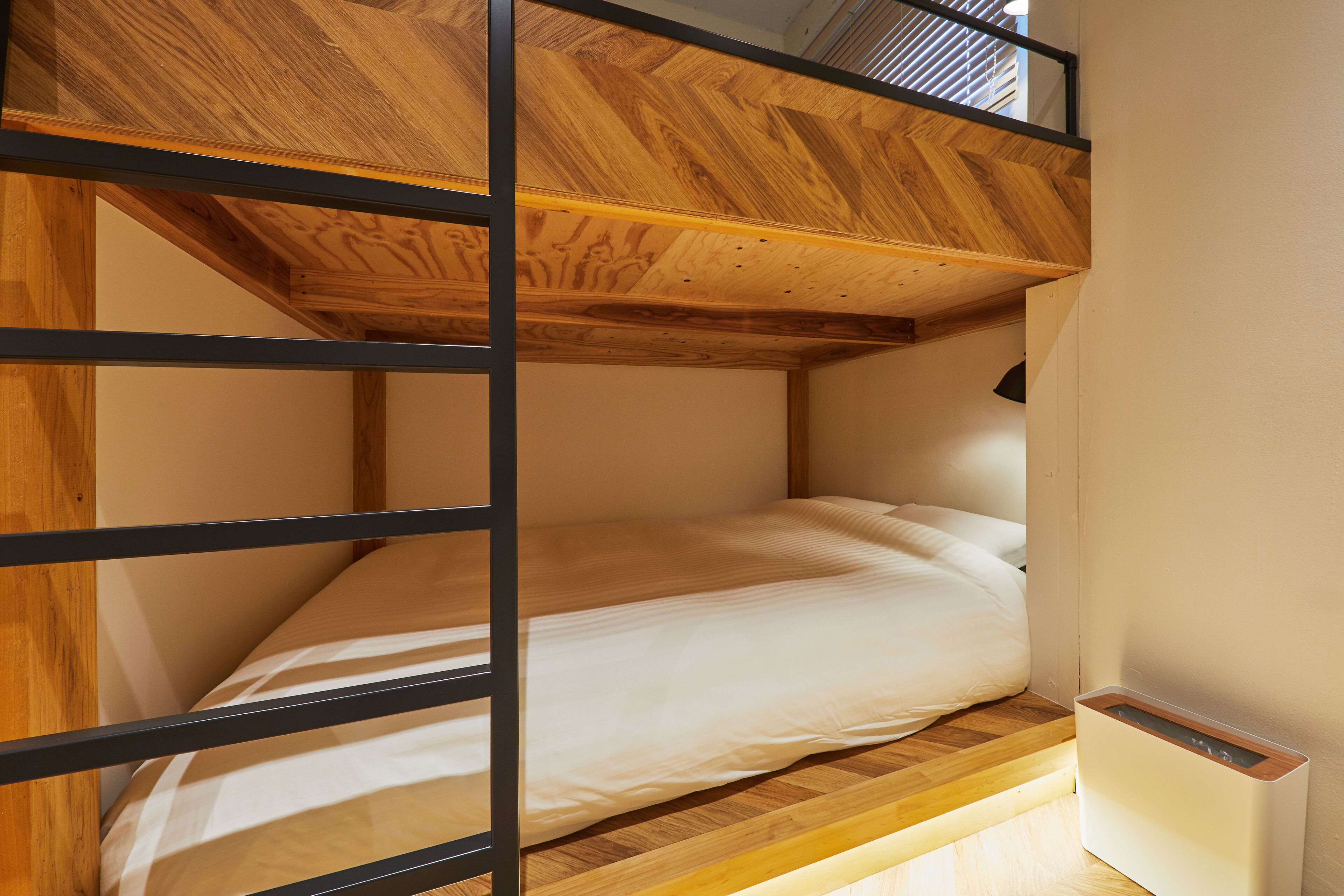 Un lit superposé avec une tête de lit en bois et une table de chevet.