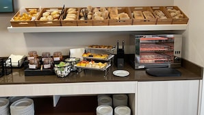 A buffet setup with various food items and a commercial oven. - Cascais City Beach Hotel (Cascais)