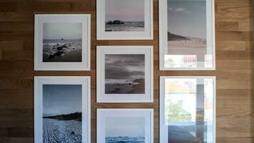 Seis fotografías enmarcadas de paisajes costeros dispuestas sobre una pared de madera.