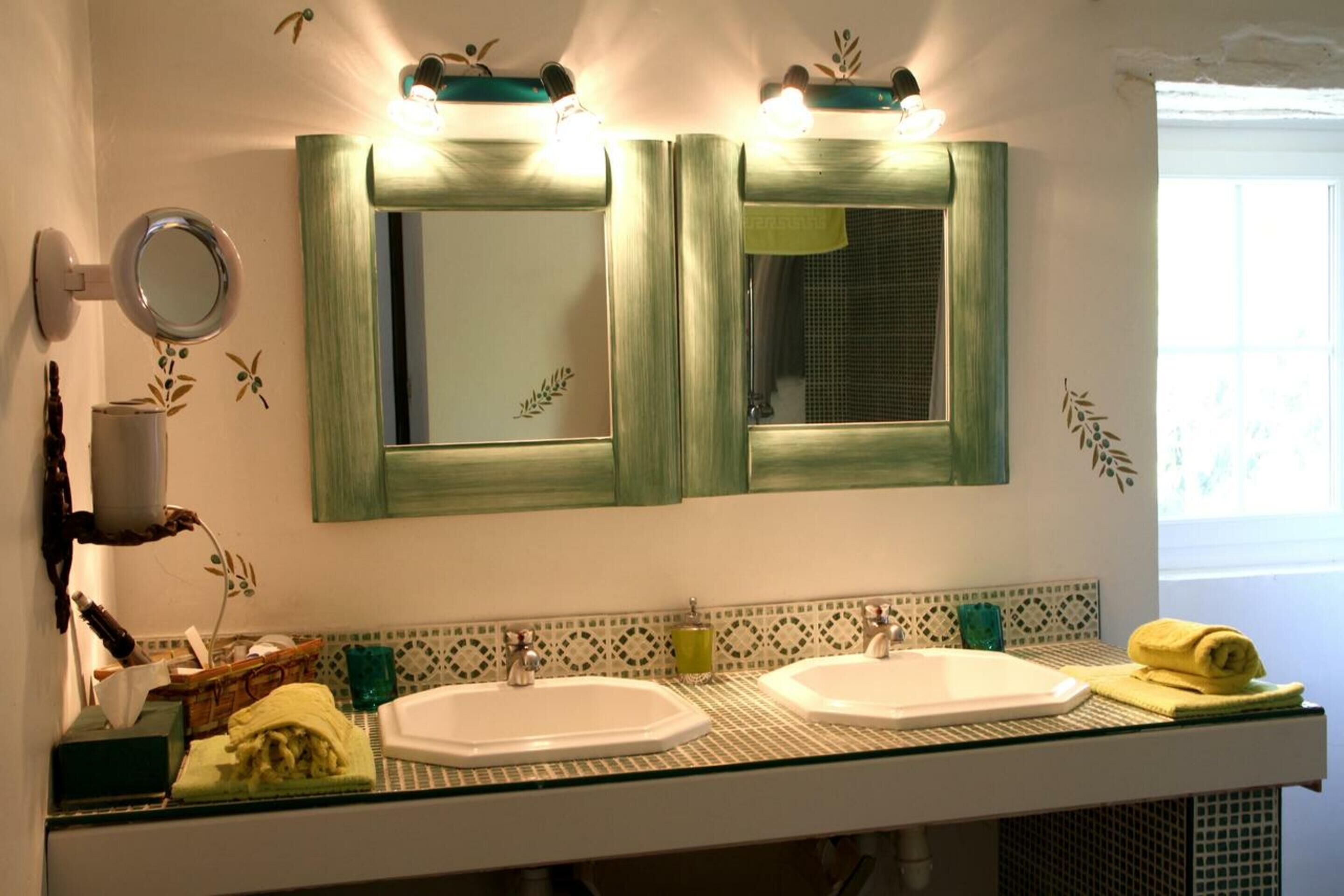 A bathroom with two sinks, a mirror, and a towel rack.
