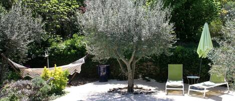 Una piscina al aire libre, sombrillas, sillones reclinables de piscina