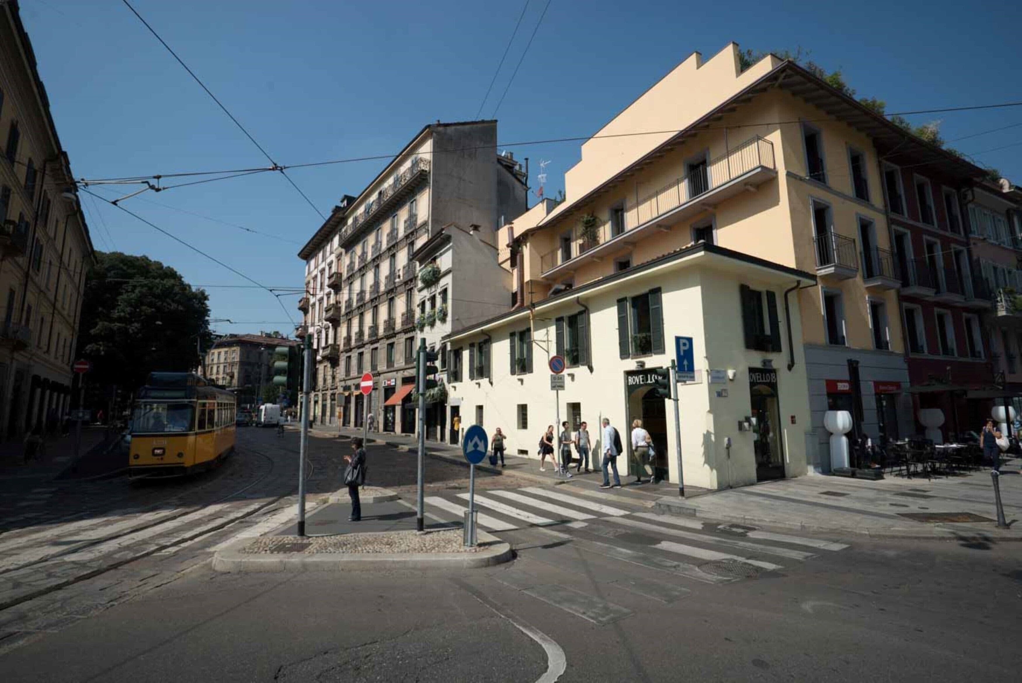 Un carrefour où passe un tramway, des immeubles avec des balcons et un passage piéton.