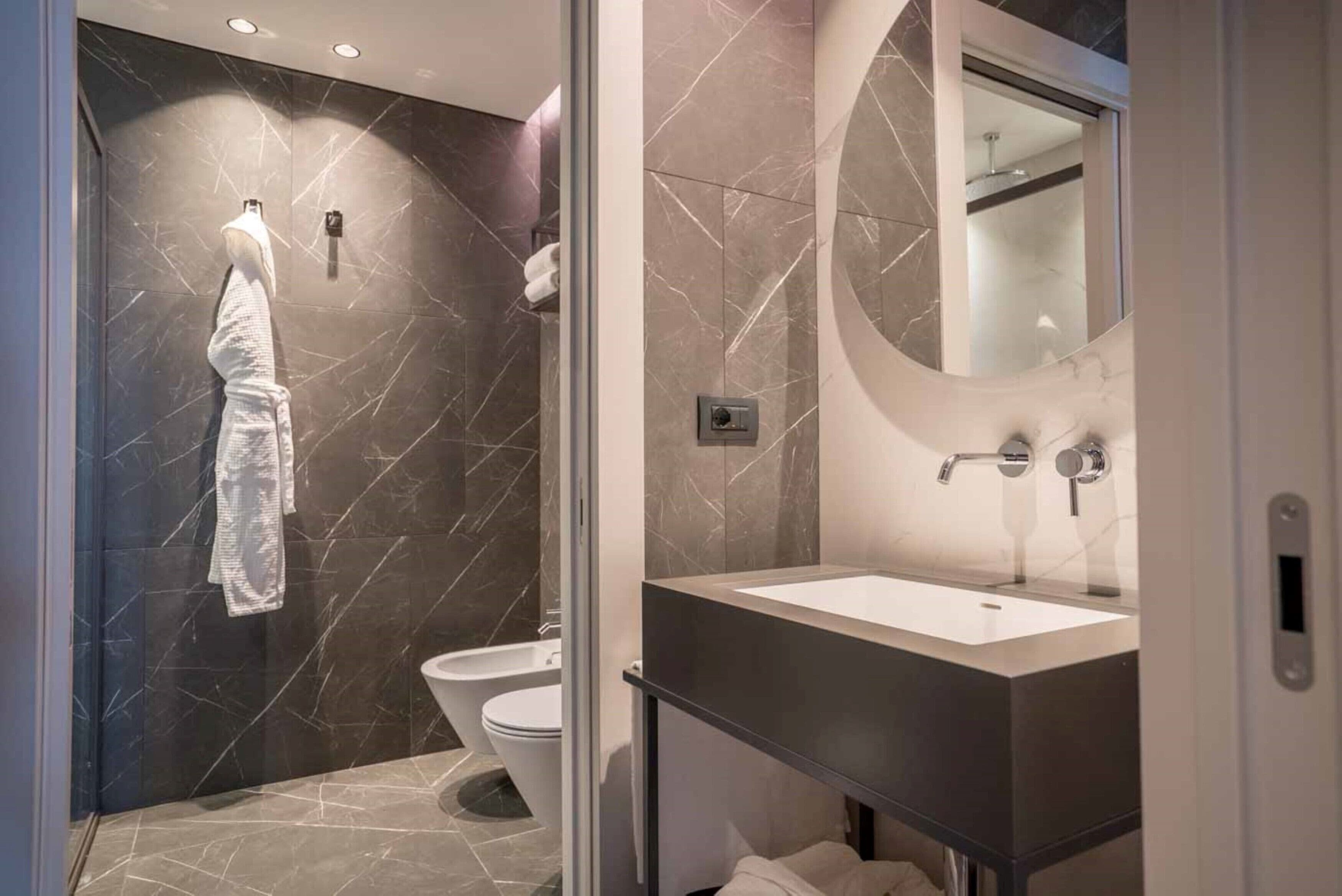 A modern bathroom with a glass shower enclosure, a toilet, and a vanity with a mirror.