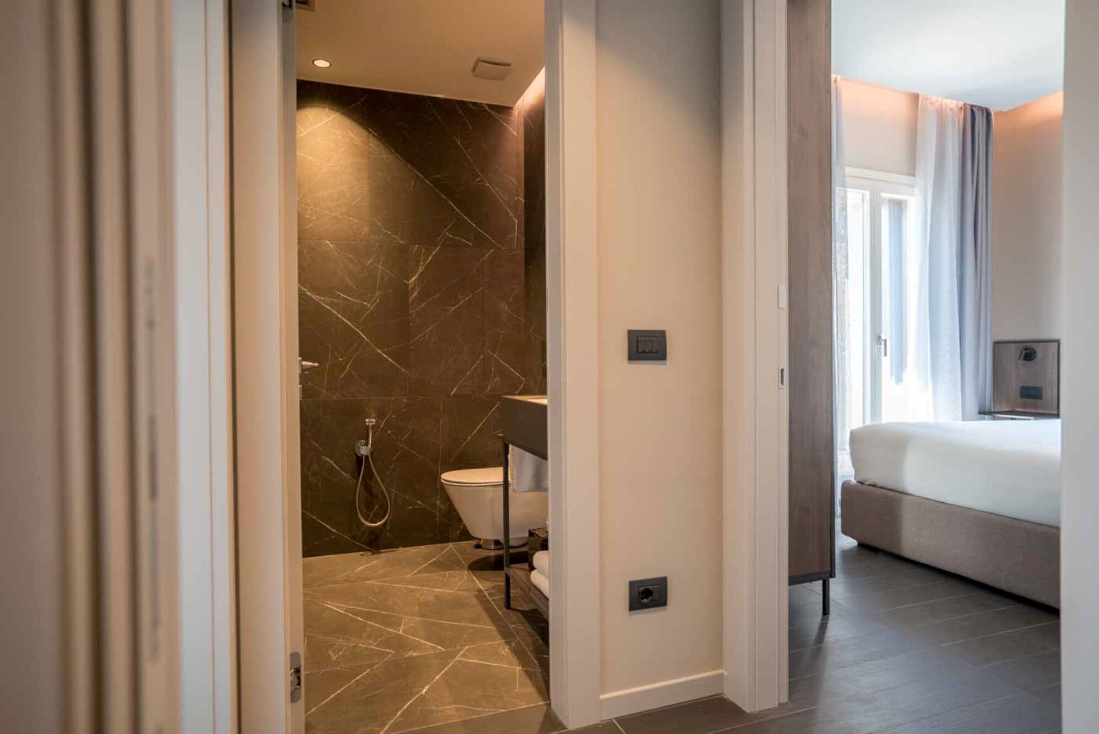 Ein modernes Badezimmer mit Marmorboden, Toilette und Duschbereich.