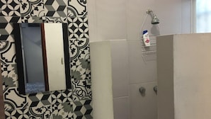 Un baño con lavamanos, espejo y ducha.