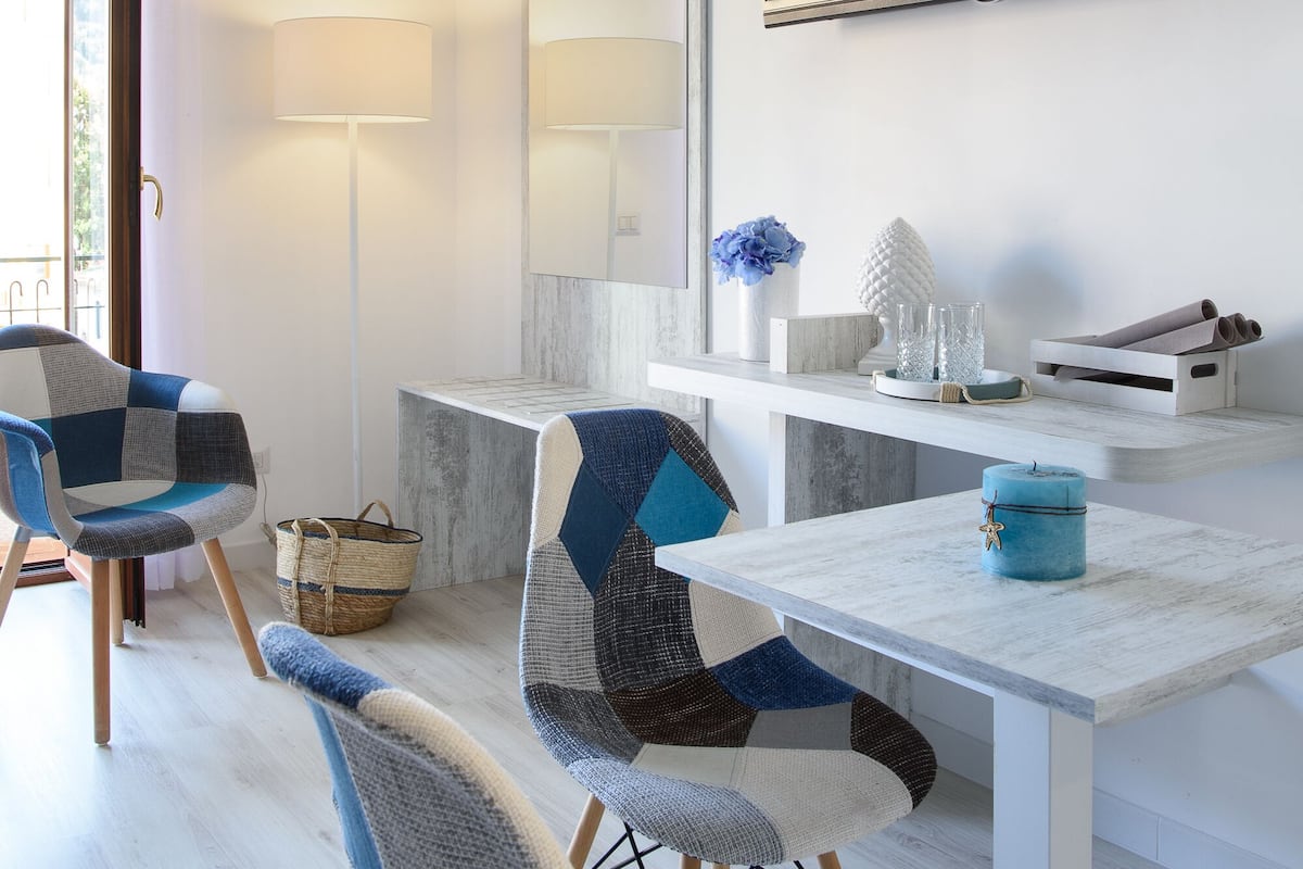 Een moderne woonkamer met een flatscreen televisie, een bank, een eettafel en een vloerlamp.