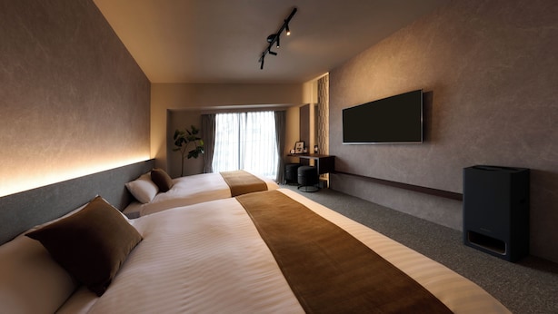 A hotel room with a large bed, a desk, a TV, and a plant. - Residence Hotel Hakata 20 (Fukuoka)