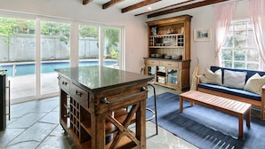 A spacious kitchen with a large island, wooden beams, and a view of a backyard swimming pool. - Private Heated Pool, Great Location by Pulaski Square in Historic District (Savannah)
