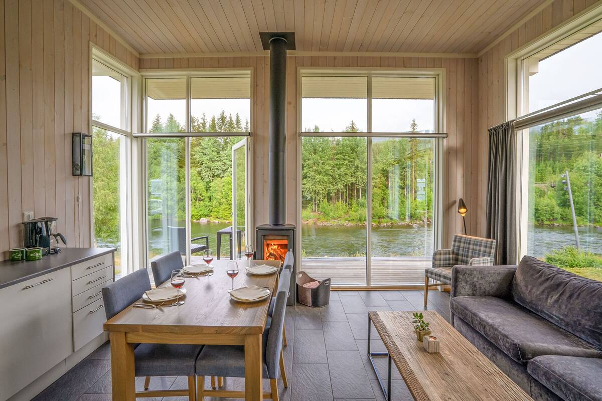 Um interior moderno com área de jantar, um sofá e lareira.