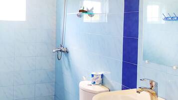 Bagno con toilette, bidet, lavabo e pareti piastrellate di blu.