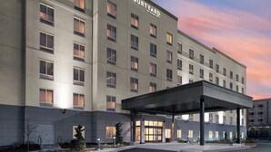 Un hotel Courtyard by Marriott con entrada cubierta, varios pisos y una fachada bien iluminada.