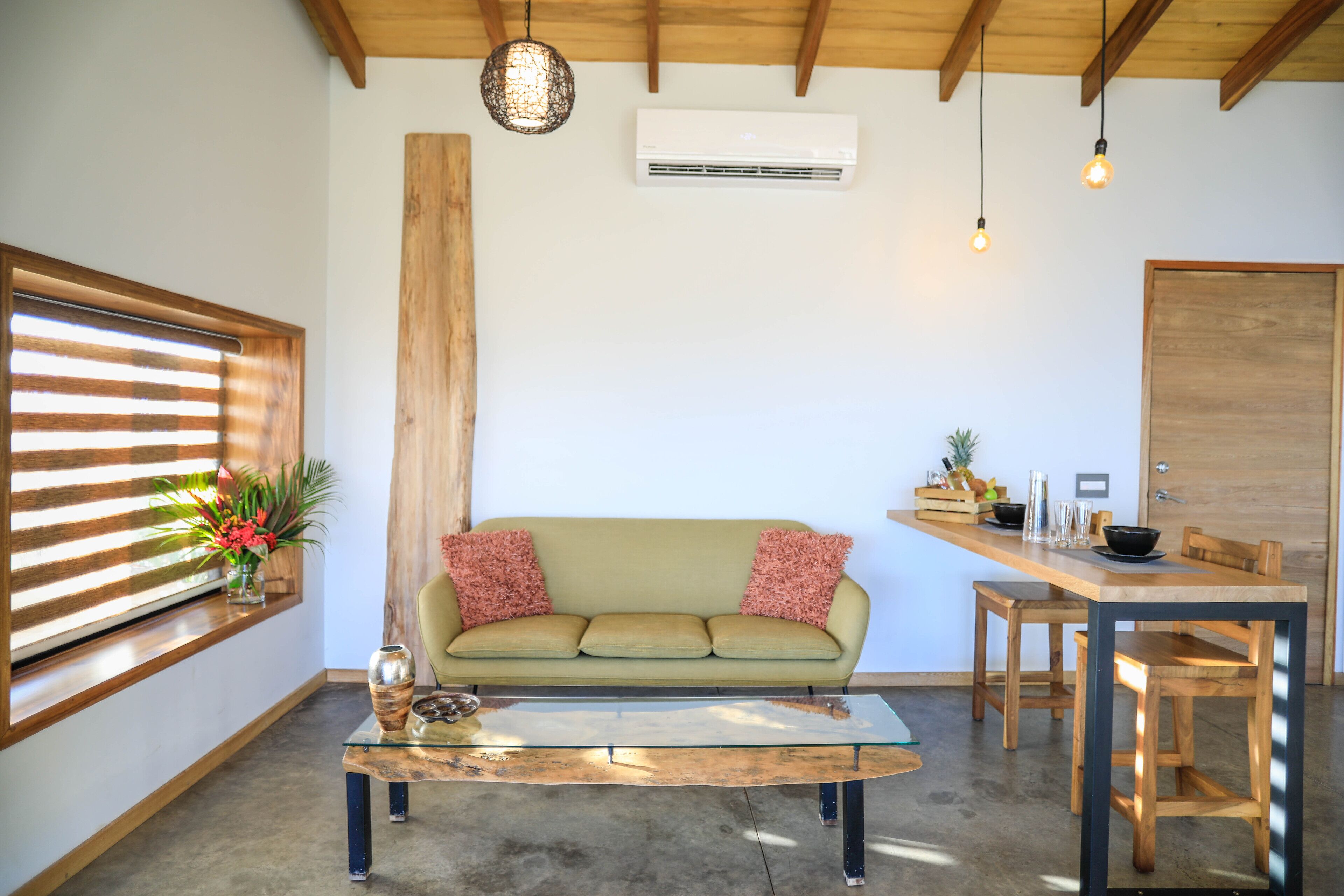 Una sala de estar moderna con sofá, mesa de centro y comedor.