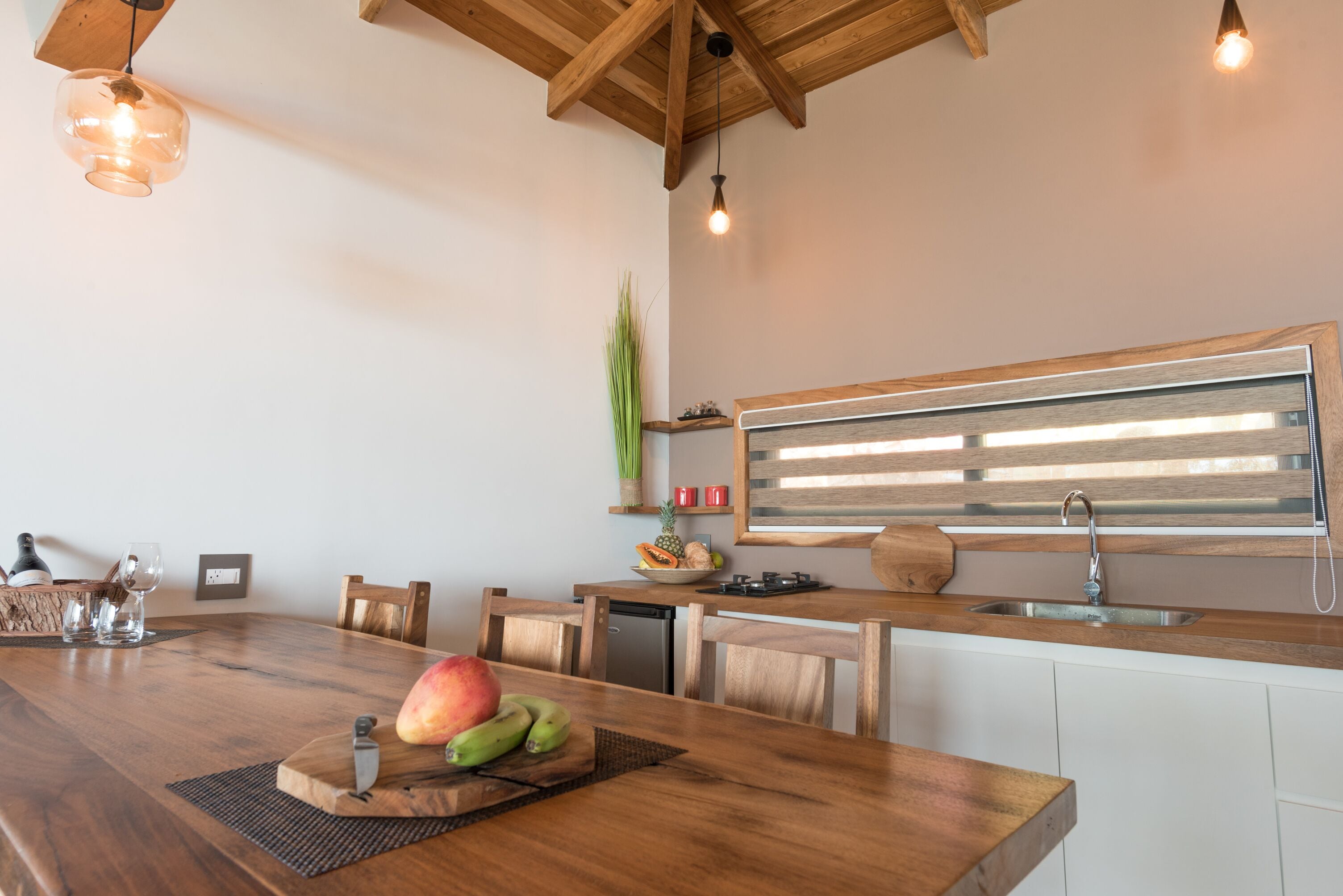 Een moderne keuken met houten aanrecht, een inbouwspoelbak en een centraal eiland met fruit.