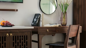 Ein Holztisch mit einem Laptop, Büchern und einer Blumenvase.