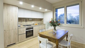 Une cuisine moderne avec des meubles en bois, une cuisinière à gaz et une table à manger avec des chaises.