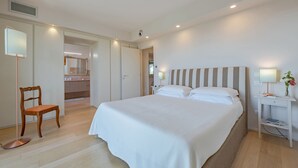 Une chambre à coucher avec un grand lit, une table de chevet avec une lampe, une chaise et une armoire.