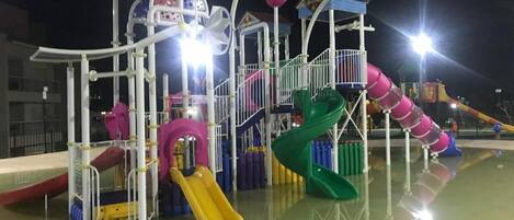 A playground with multiple slides and climbing structures.