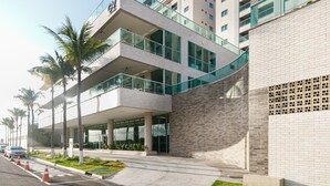 Un bâtiment moderne à plusieurs étages, doté de grandes fenêtres et d’une balustrade en verre au niveau supérieur.