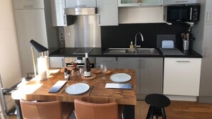 Una cocina compacta con una isla central, microondas, estufa y pileta.