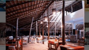 An open-air restaurant with high ceilings and exposed beams, featuring multiple dining tables and chairs. - Hotel Bocaino (San Rafael del Yuma)