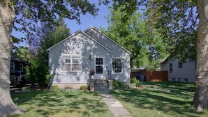 A single-story house with a front porch, a small garden, and a visible garage. - Charming home near Boise State and The Train Depot
 (Boise)