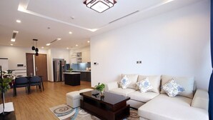 A modern living room with a sofa, coffee table, and dining area. - 3 bedroom in Metropolis near Lotte, Dao Tan (Hanoi)