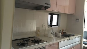 A kitchen with white cabinets, a gas stove, a window, and a sink. - Near JR AWAJI station <br> 30 min. to Kyoto .10 min. to umeda.<br> 40 min.<br> (Osaka city higashiyodogawa ku)